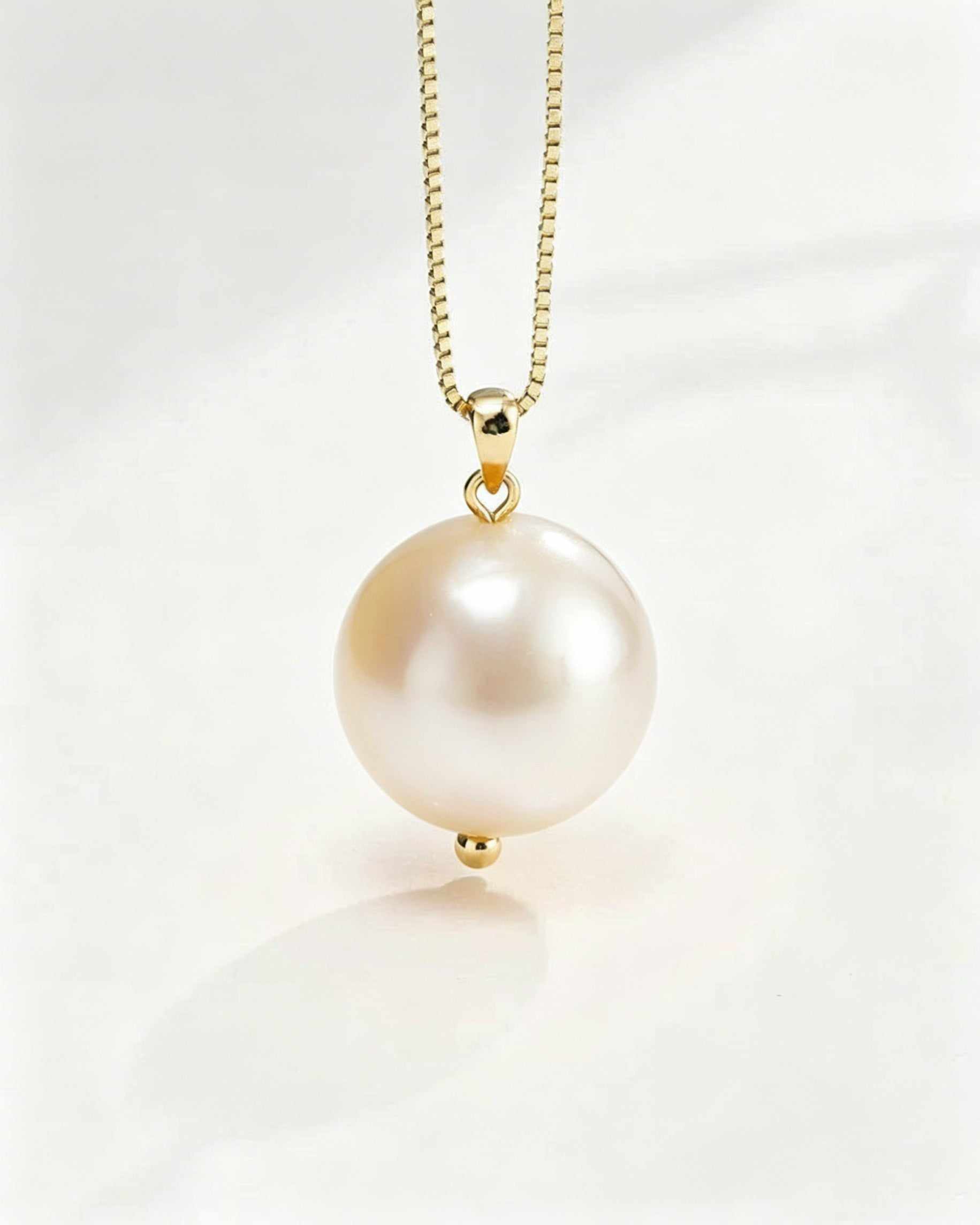 Pearl necklace with gold chain on a white background