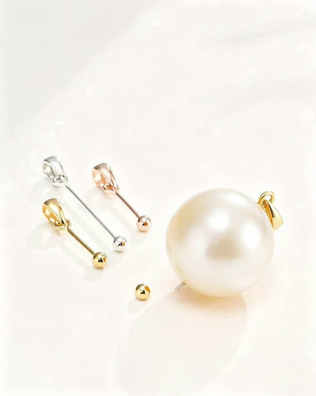 Set of pearl earrings with gold and silver clasps on a light background