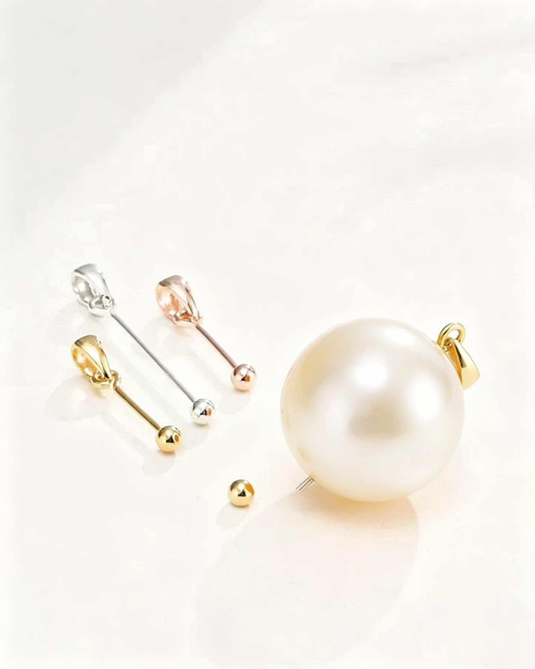 Set of pearl earrings with gold and silver clasps on a light background