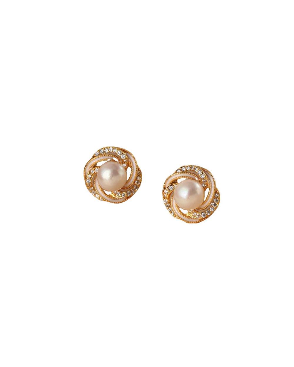 Pair of gold earrings with pearl center on a white background