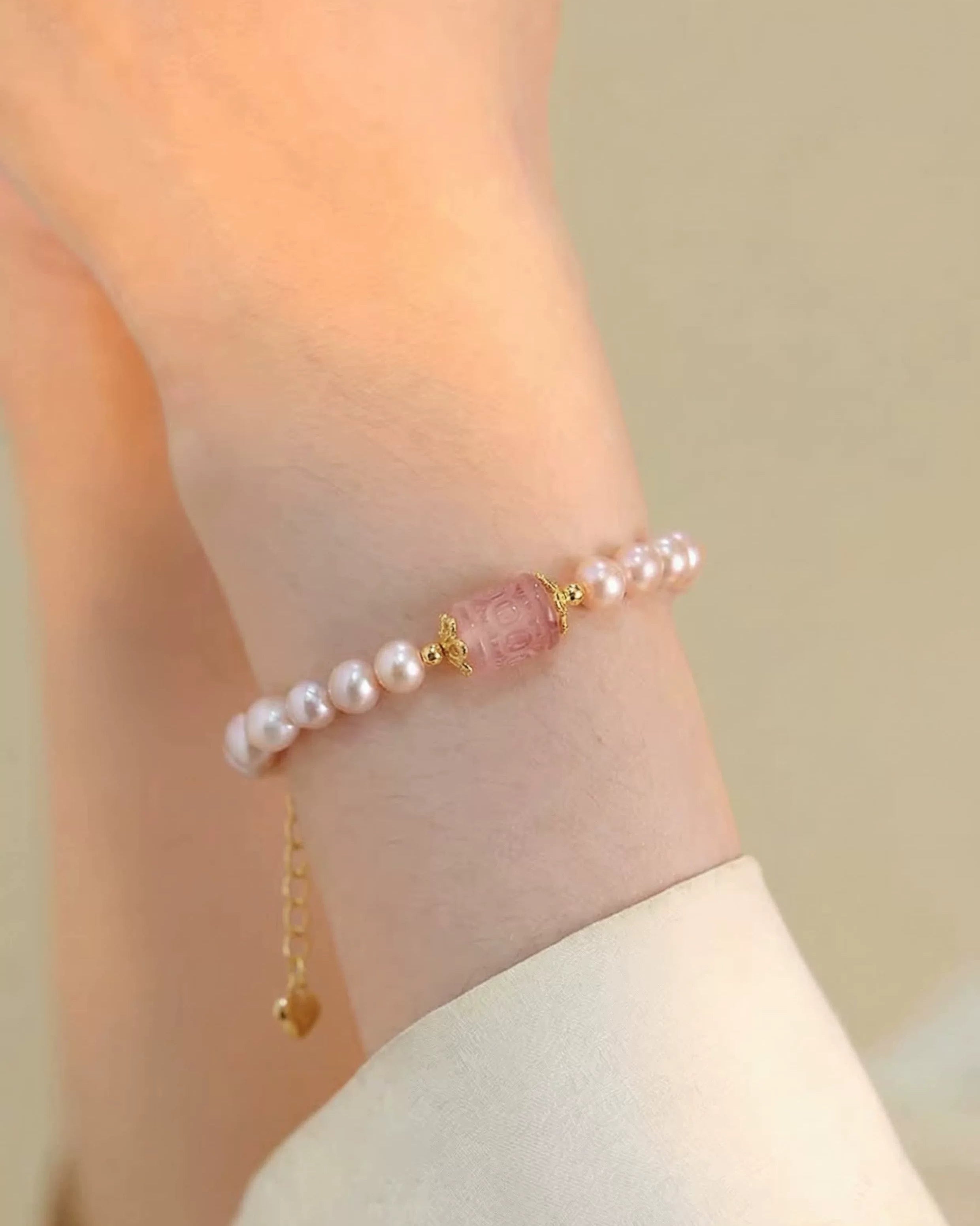 Pearl and pink stone bracelet on a wrist with a soft background