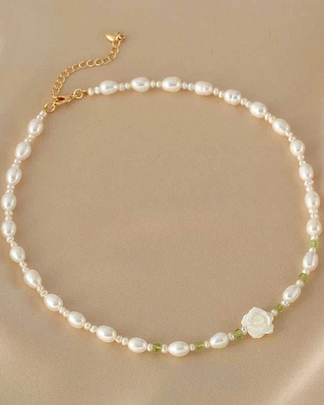 Pearl necklace with a floral pendant on a beige background