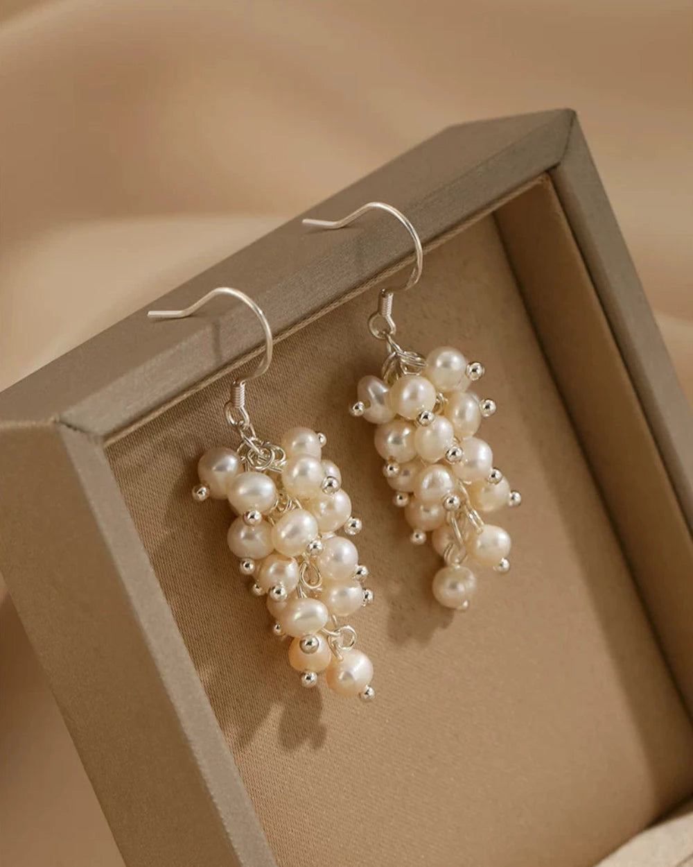Pearl earrings on a beige background