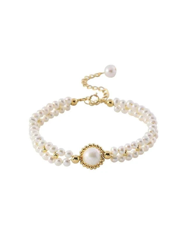 Pearl bracelet with gold accents on a white background