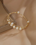 Gold bracelet with pearls on a beige background