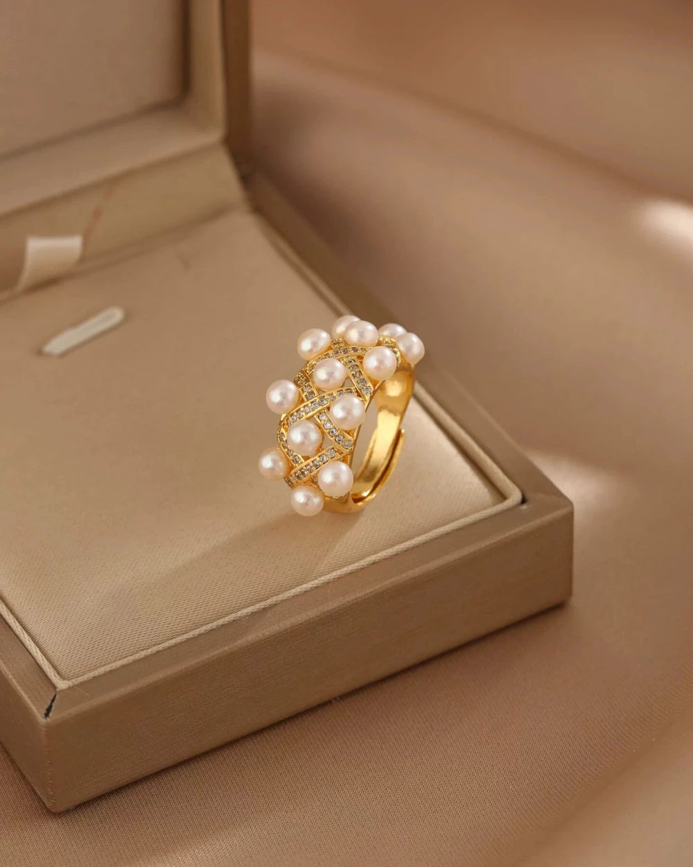 Gold ring with pearls on a beige jewelry box