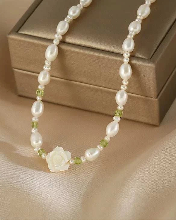 Pearl necklace with a flower pendant on a beige fabric background