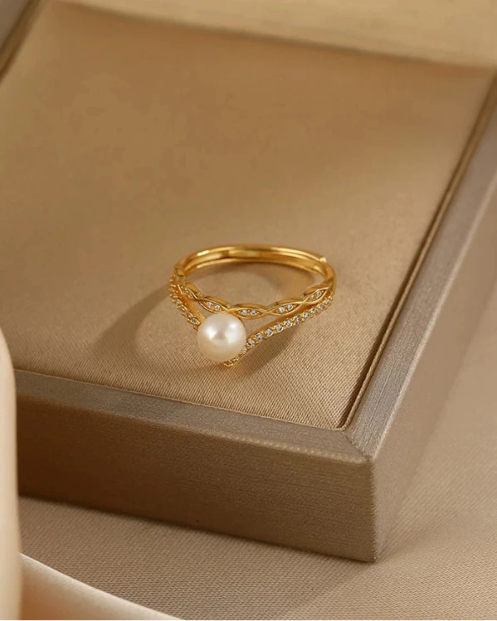 Gold ring with a pearl on a beige jewelry box