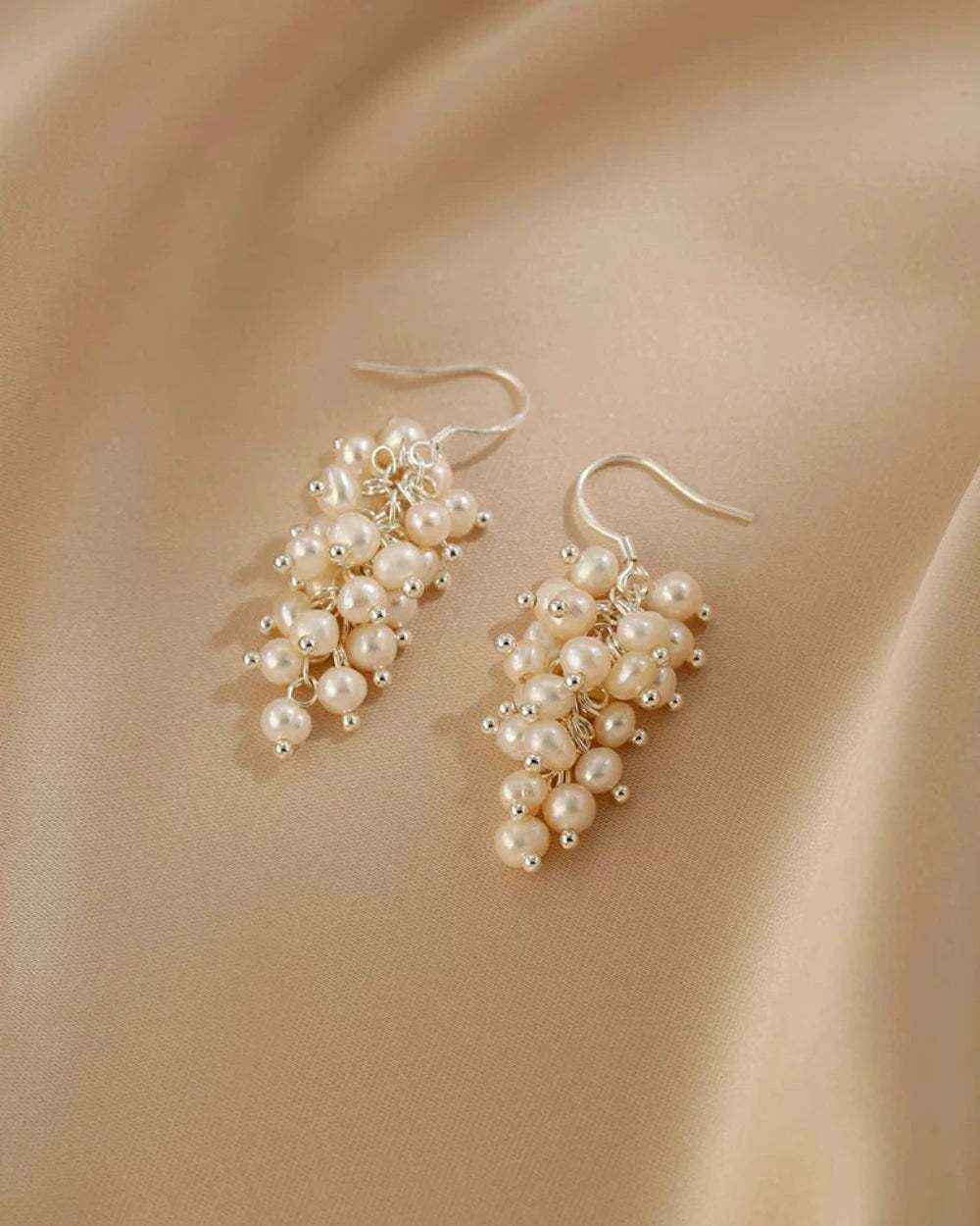 Pair of pearl earrings on a beige background