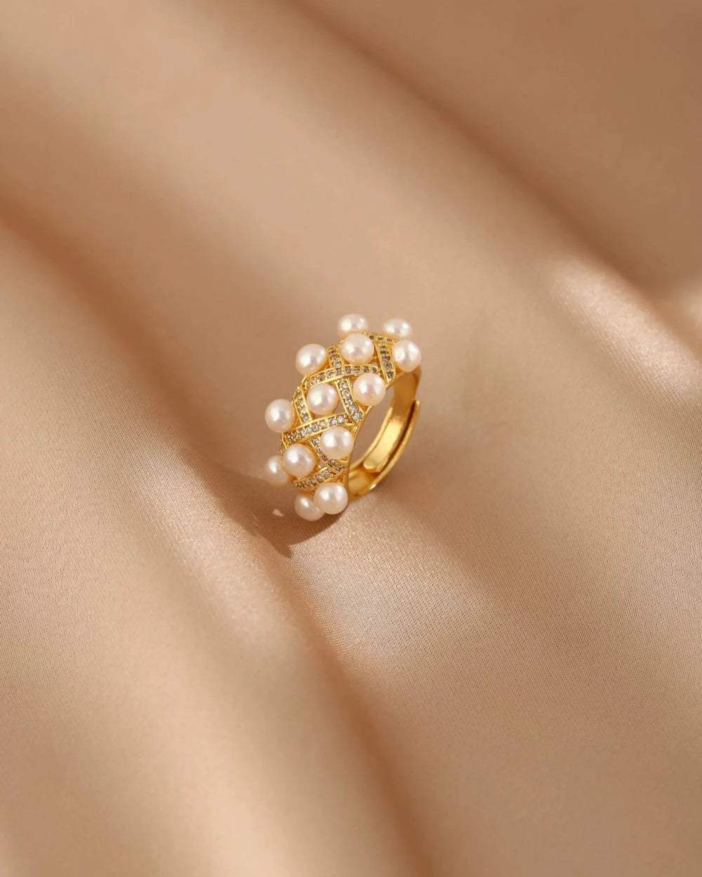Gold ring with pearls on a beige fabric background