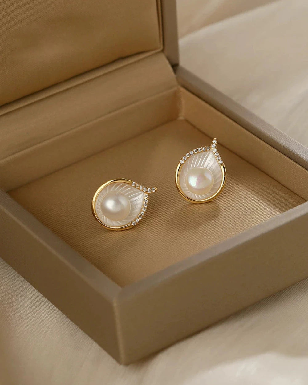 Pearl earrings with gold accents in a jewelry box