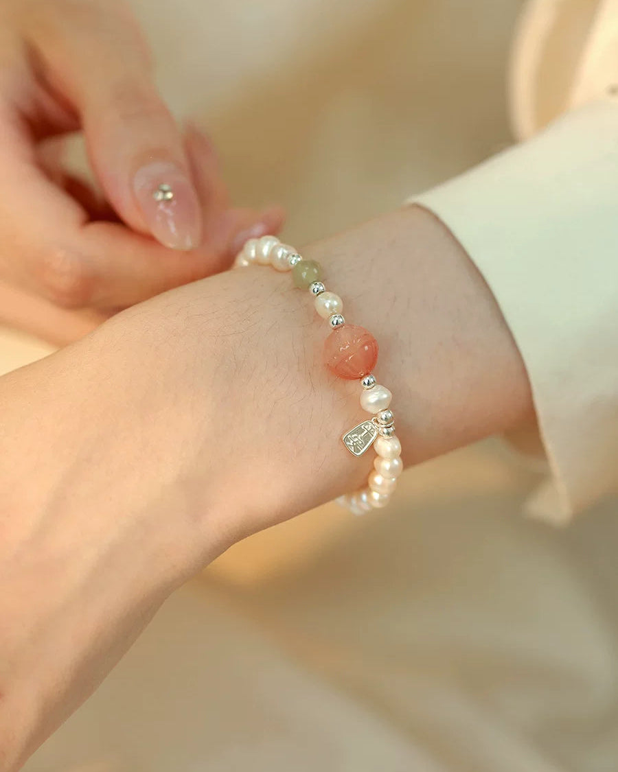 Close-up of a hand wearing a pearl bracelet on a soft background