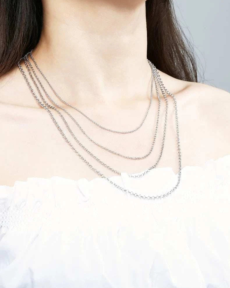 Silver necklace on a person with a plain background