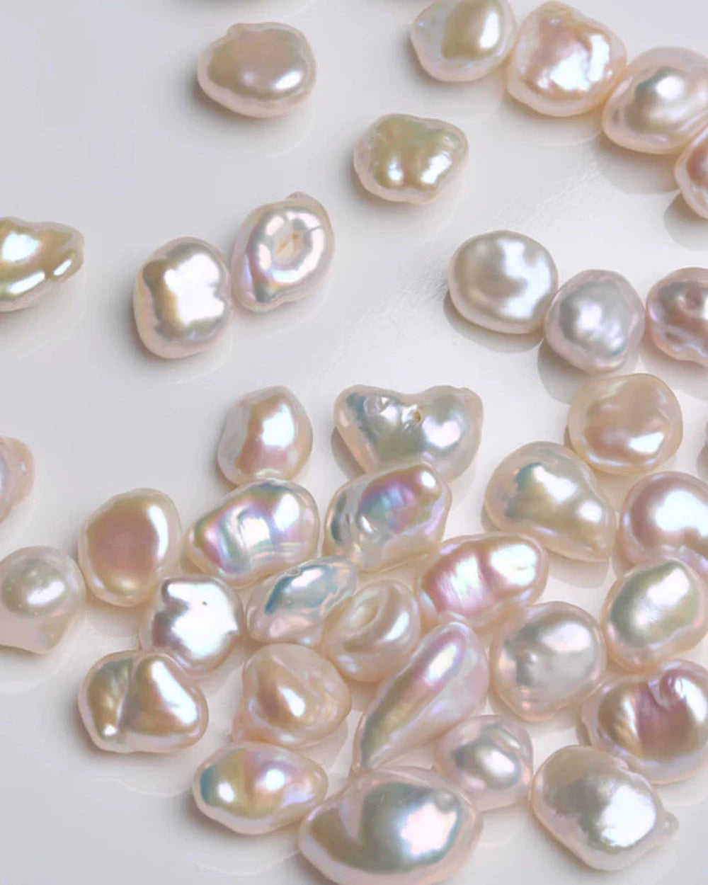 Collection of light pink and white pearls on a white background
