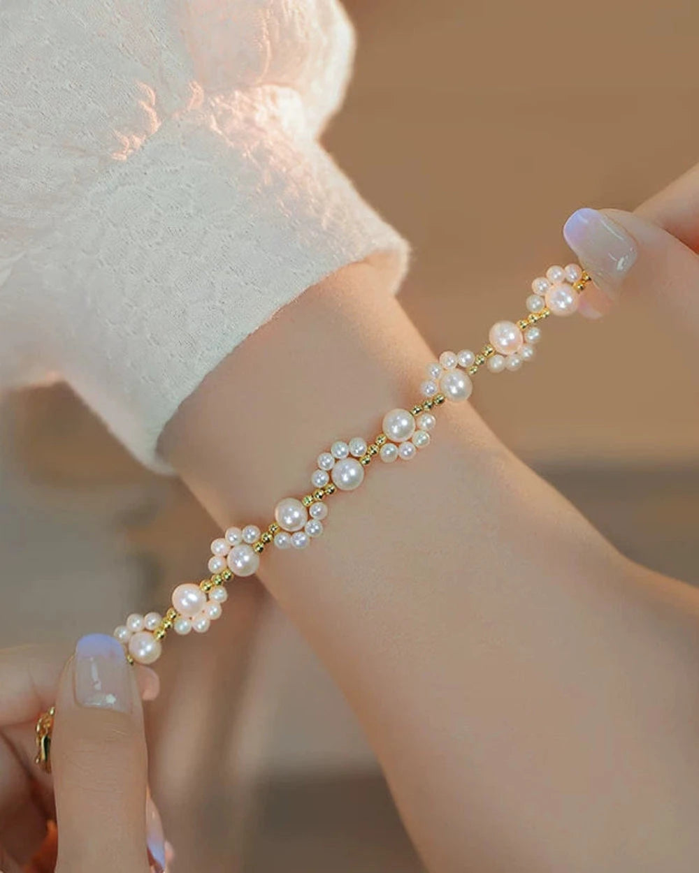 Close-up of a hand wearing a delicate pearl bracelet with a soft focus background