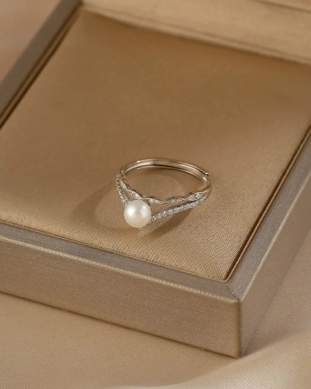 Silver ring with a pearl on a beige jewelry box