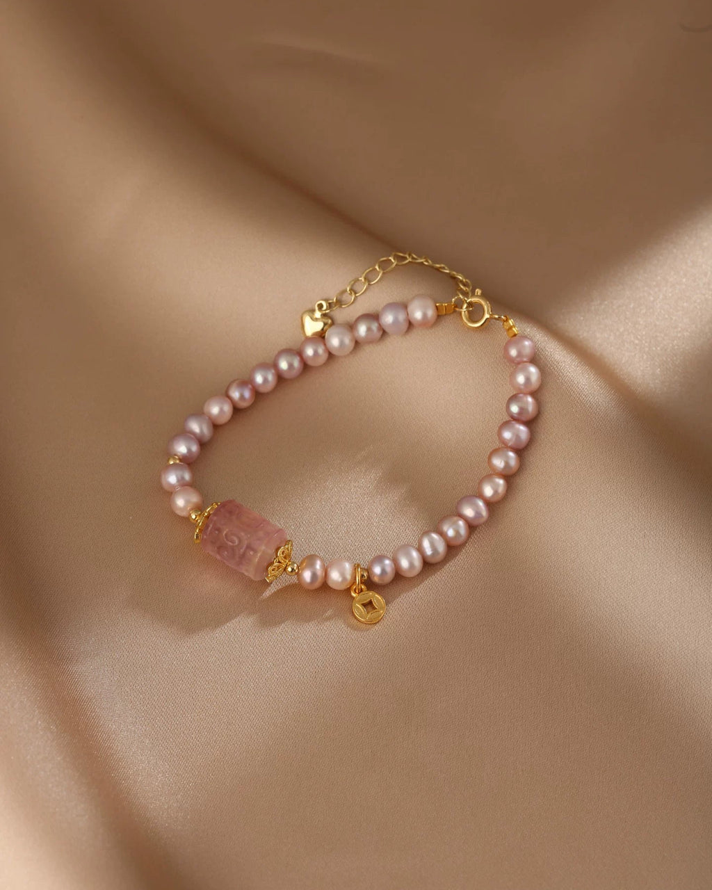 Pearl bracelet with gold accents on a beige fabric background