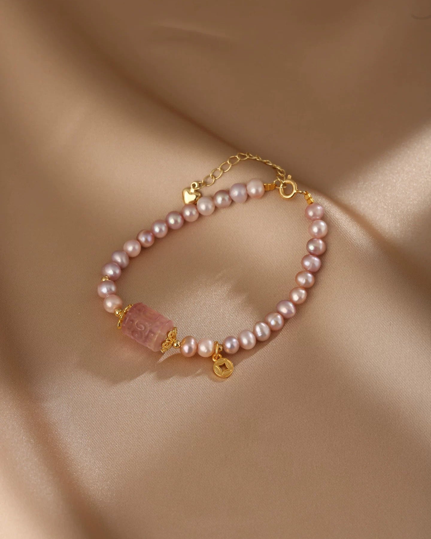 Pearl bracelet with gold accents on a beige fabric background