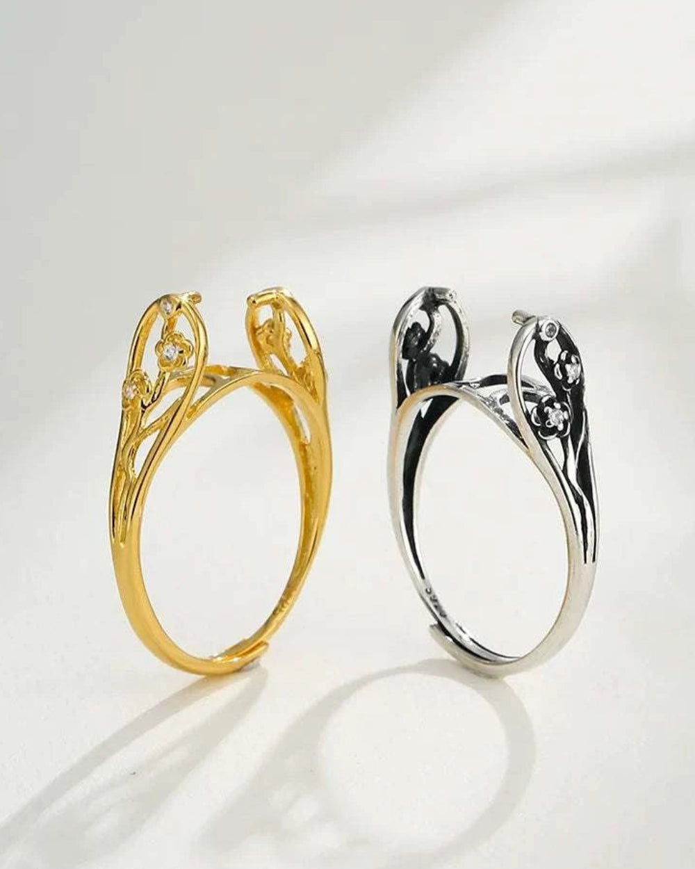 Gold and silver rings with intricate designs on a white background