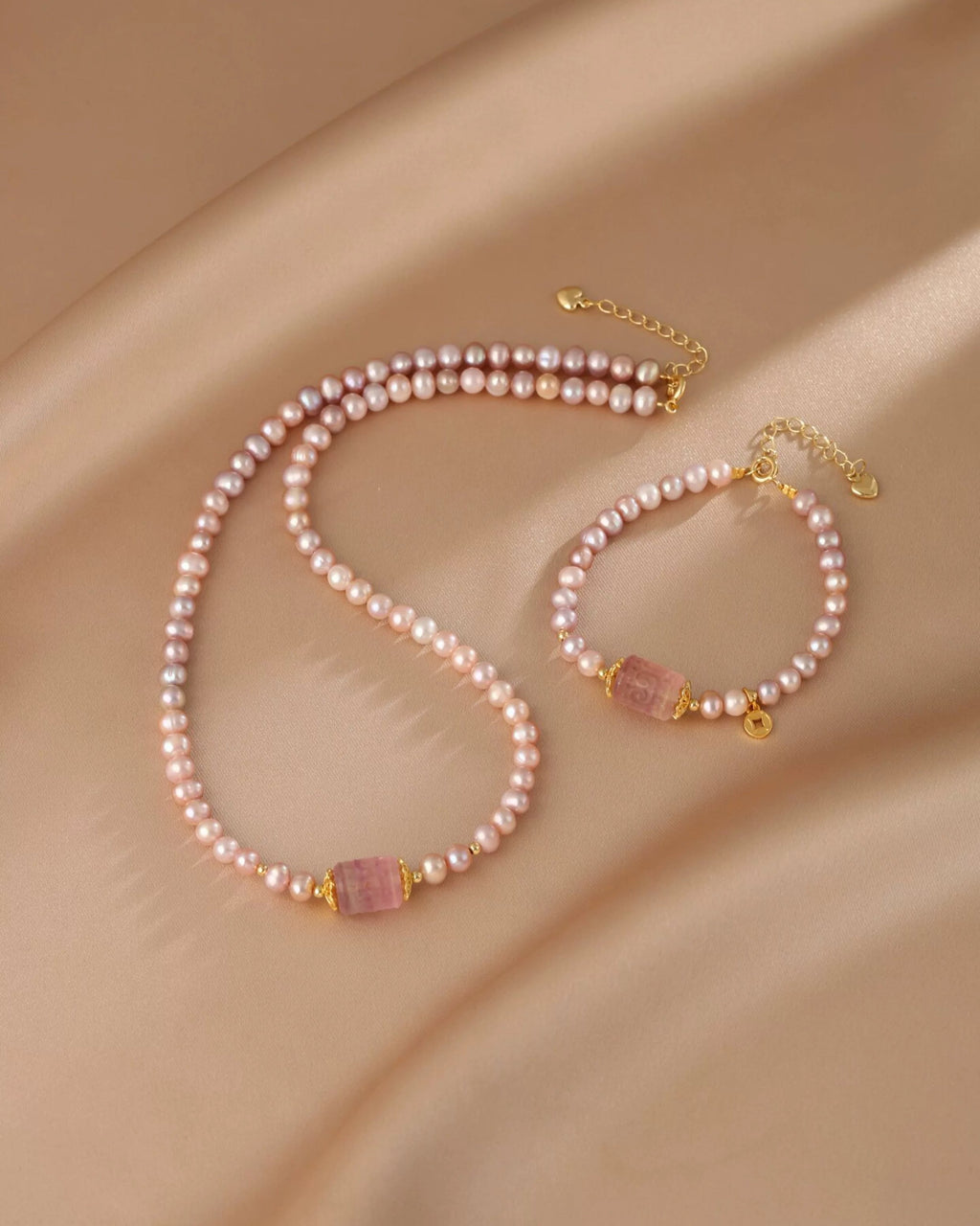 Pearl necklace and bracelet set on a beige fabric background
