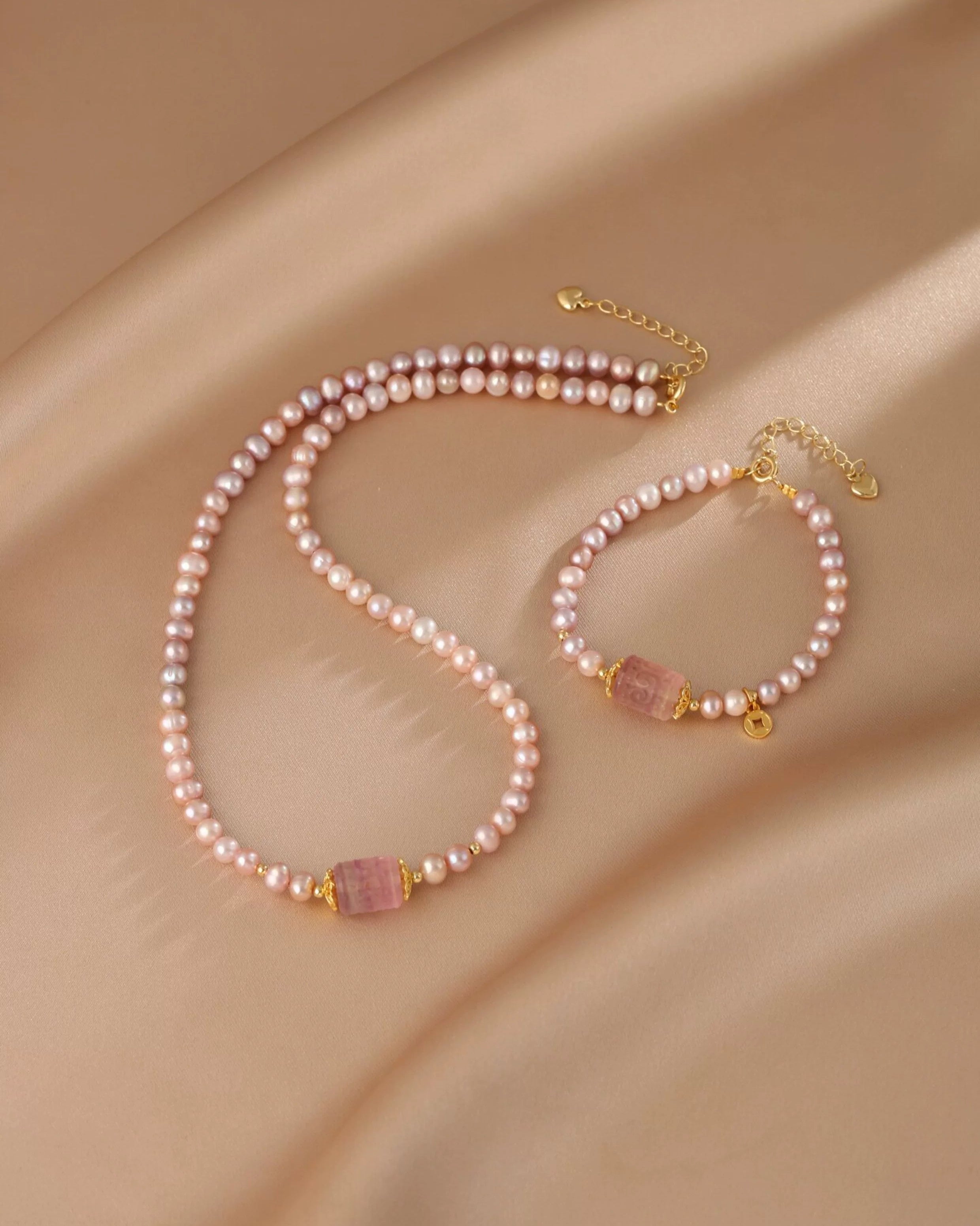Pearl necklace and bracelet set on a beige fabric background