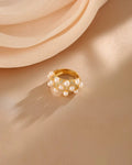 Gold ring with pearls on a beige fabric background