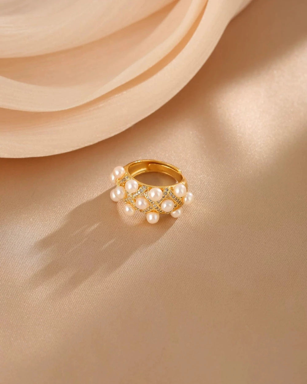 Gold ring with pearls on a beige fabric background