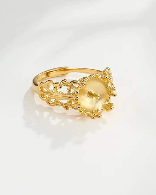 Gold ring with intricate design on a white background