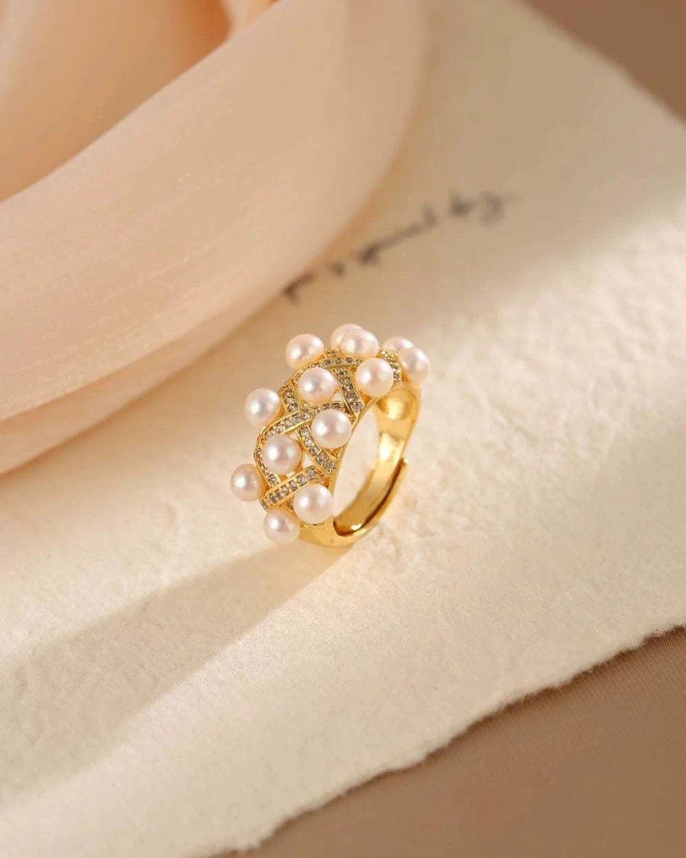 Gold ring with pearls on a soft fabric background