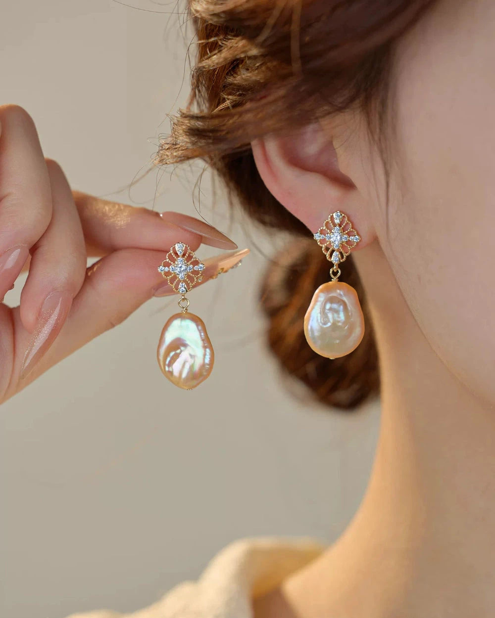 Pearl earrings being worn with a blurred background