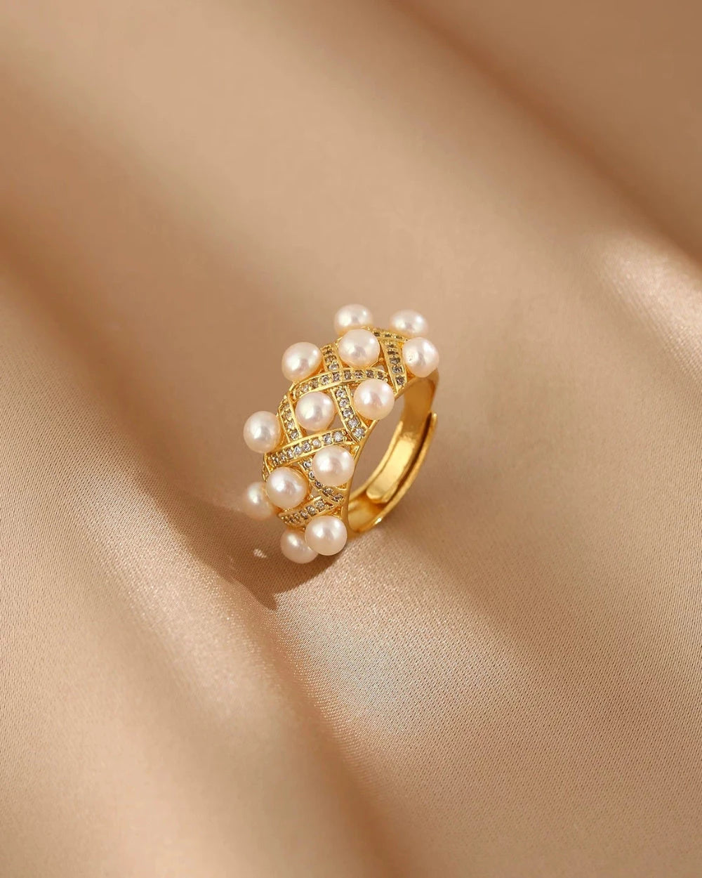 Gold ring with pearls on a beige fabric background