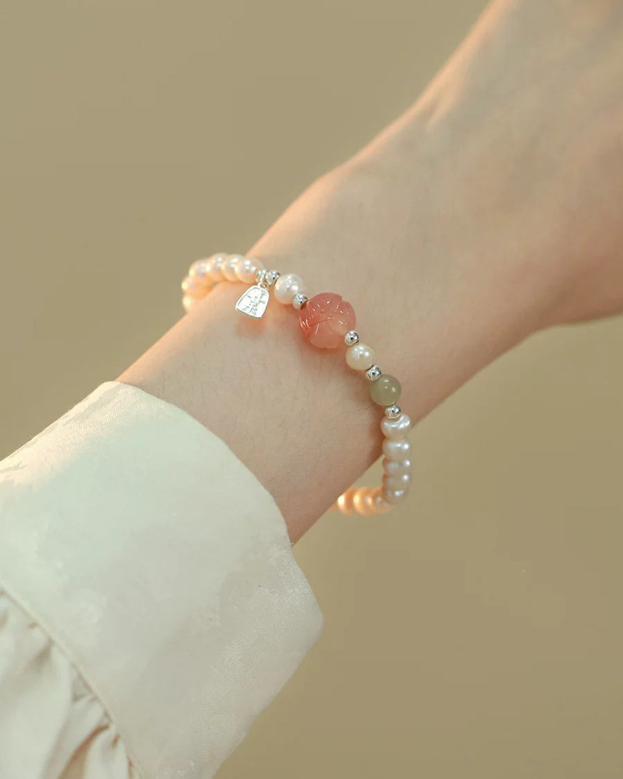 Bracelet with pink and white beads on a wrist against a beige background