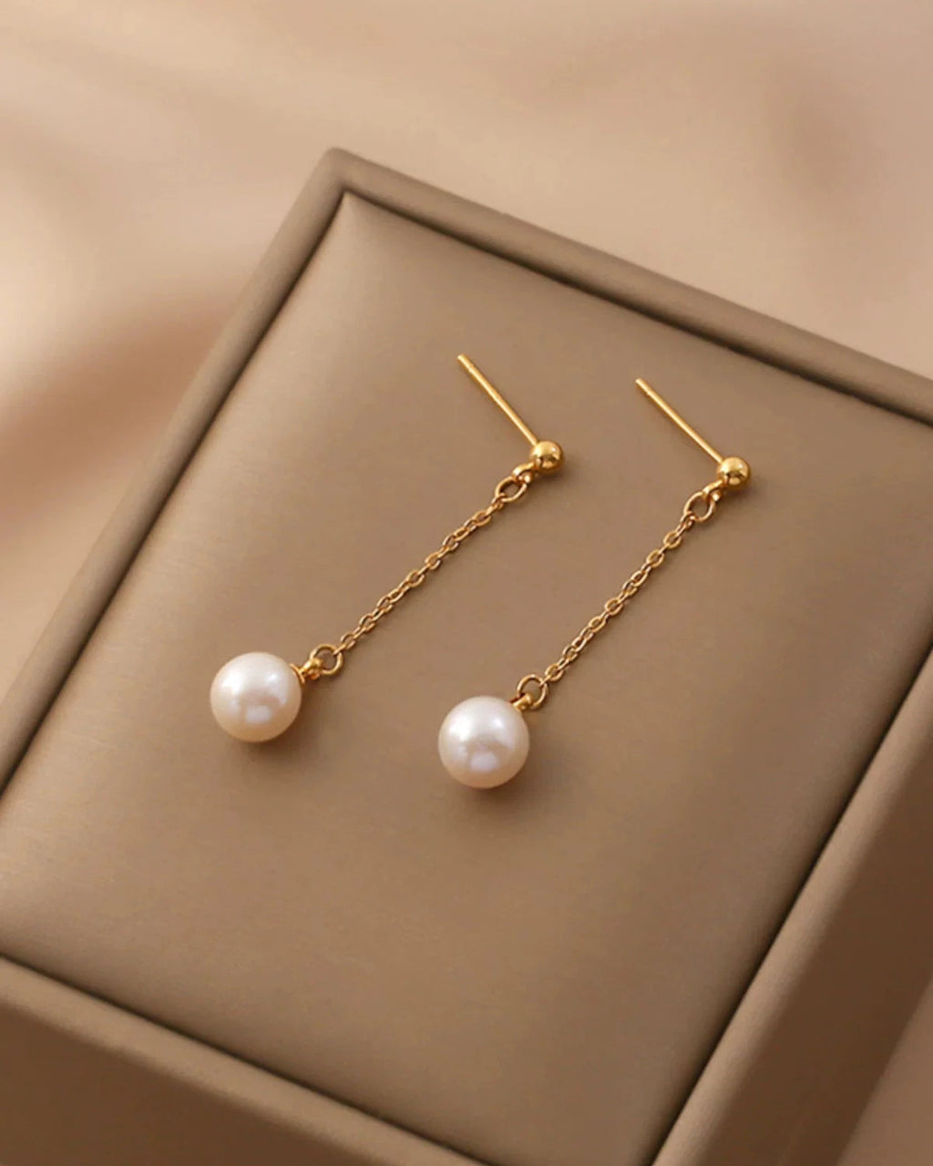 Long stylish natural freshwater pearl drop earrings on white background