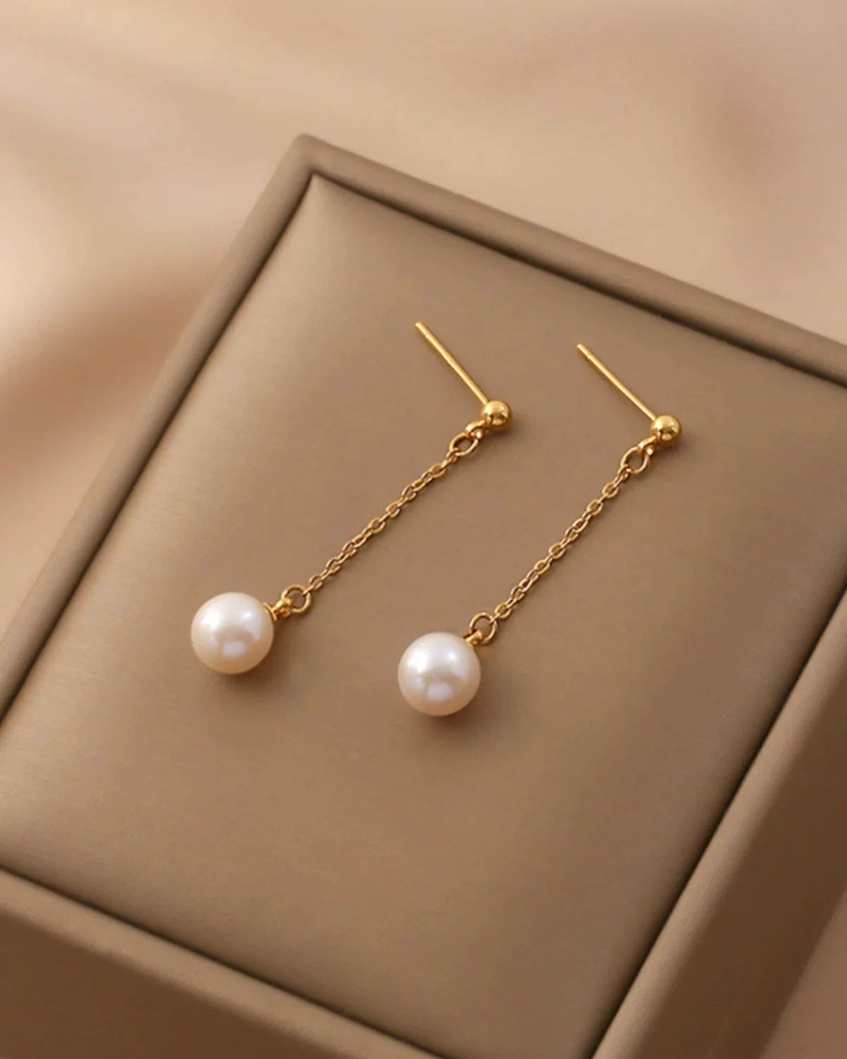Long stylish natural freshwater pearl drop earrings on white background