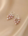 Pair of pearl earrings on a beige fabric background
