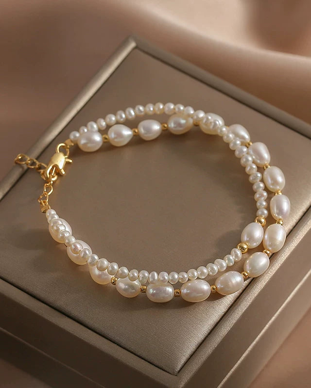 Pearl bracelet with gold accents on a beige jewelry box