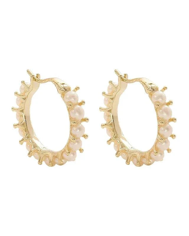 Gold hoop earrings with pearl accents on a white background