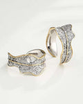 Pair of gold and silver rings with intricate designs on a white background
