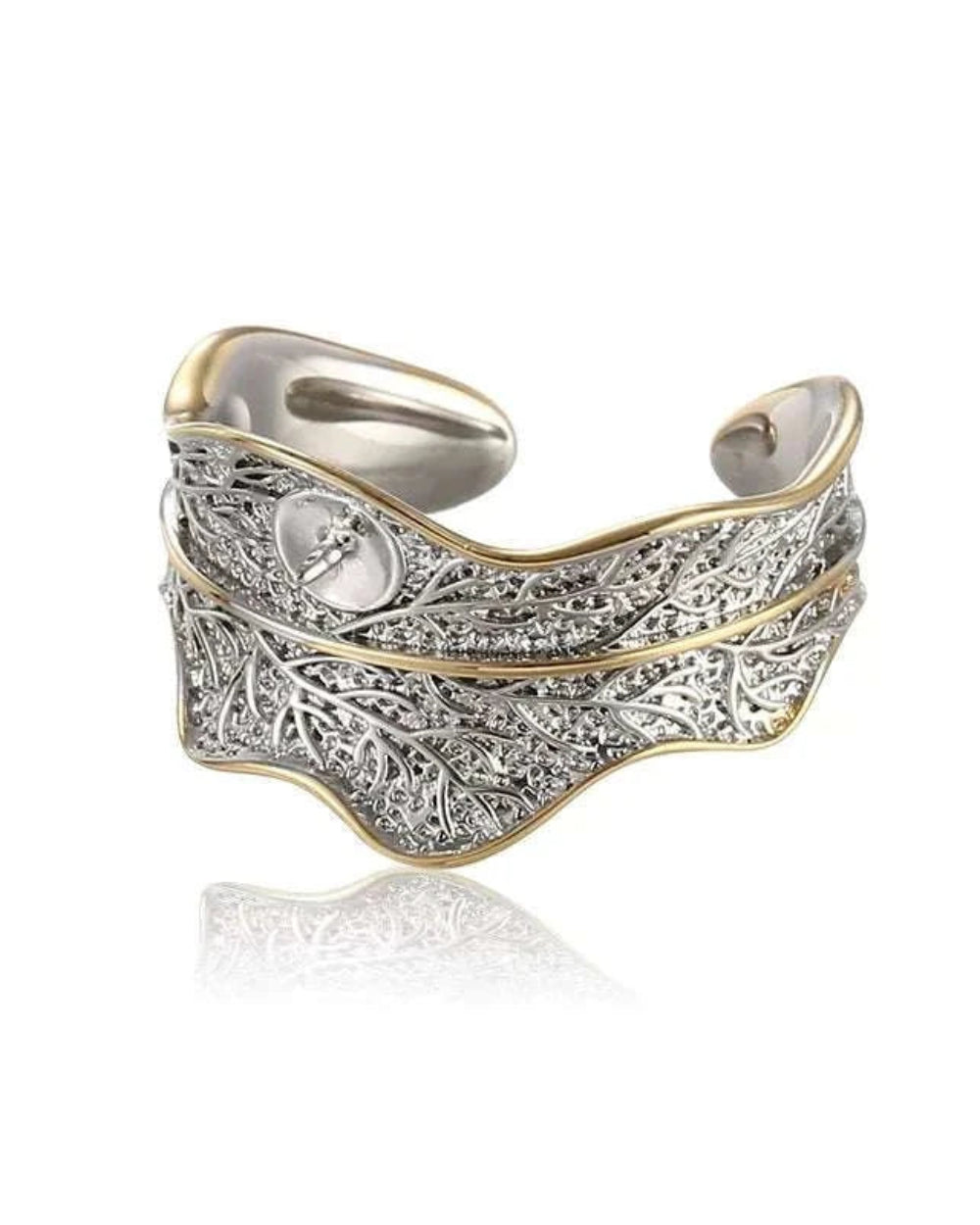 Silver and gold ring with intricate design on a white background