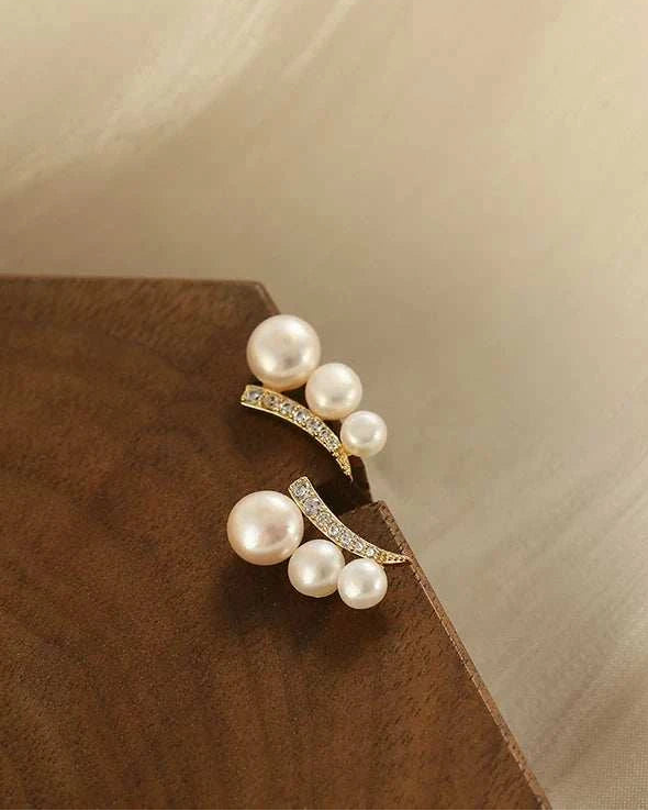 Pearl earring on a wooden surface with a neutral background