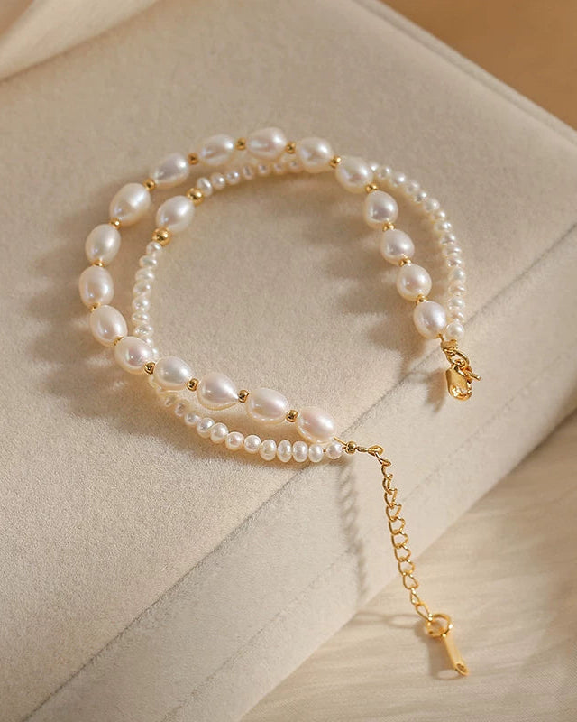 Pearl bracelet with gold accents on a beige surface