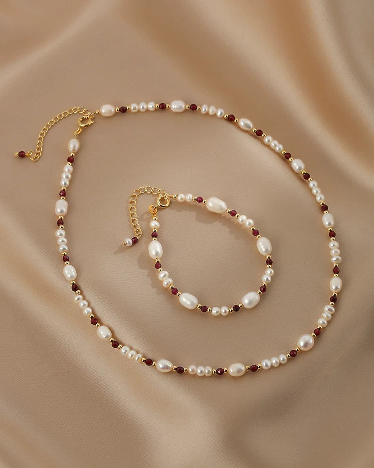 Pearl necklace and bracelet set on a beige fabric background