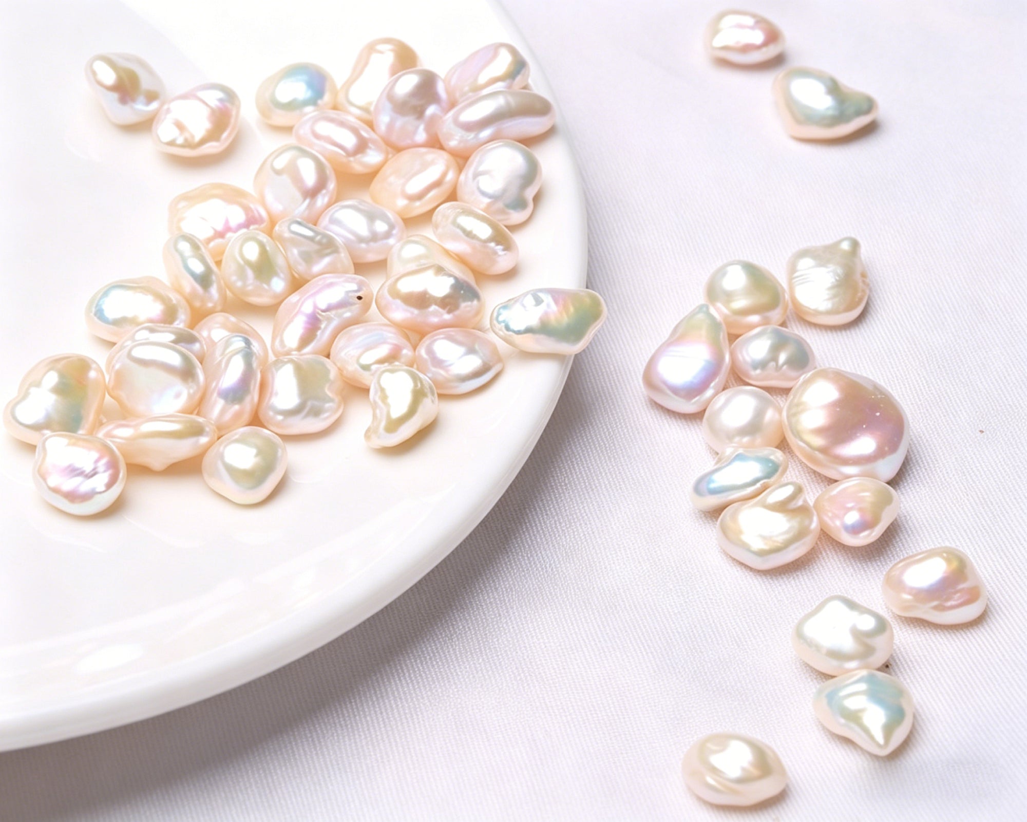 Pearl beads on a white plate and scattered on a white surface